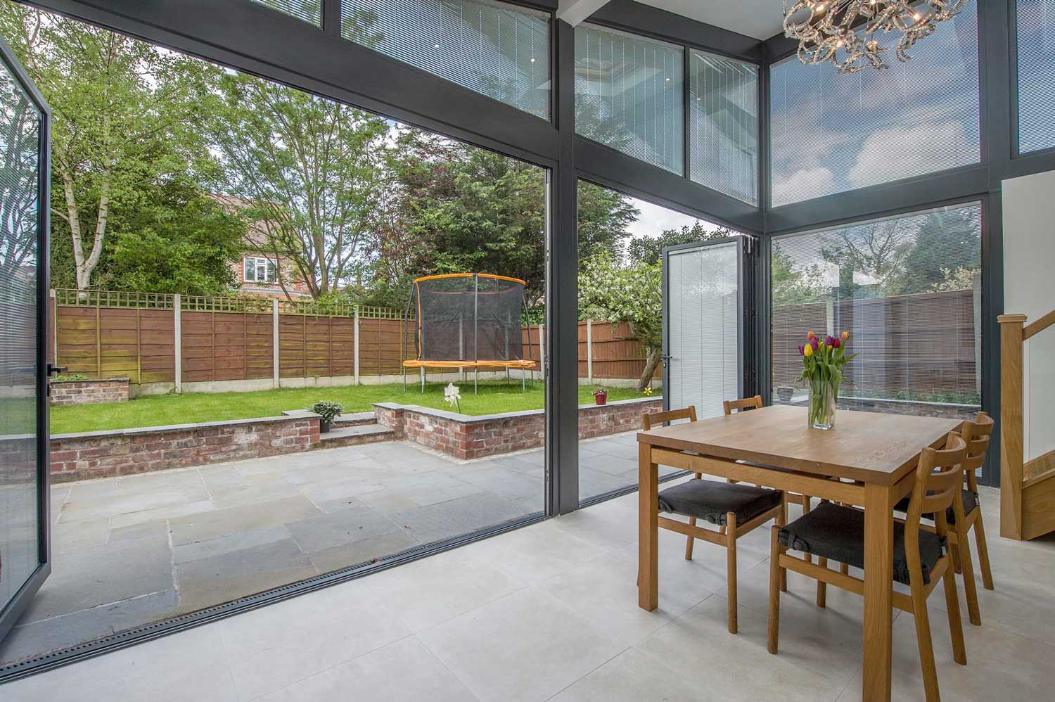 Integral Blinds for Bifold Doors: floor-to-ceiling bifold doors with integrated blinds opening to a garden