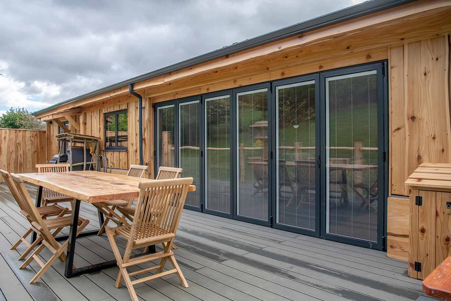 Blinds in Glass in Hatfield: integral blinds in the bifold doors of a garden lodge, viewed from the decking