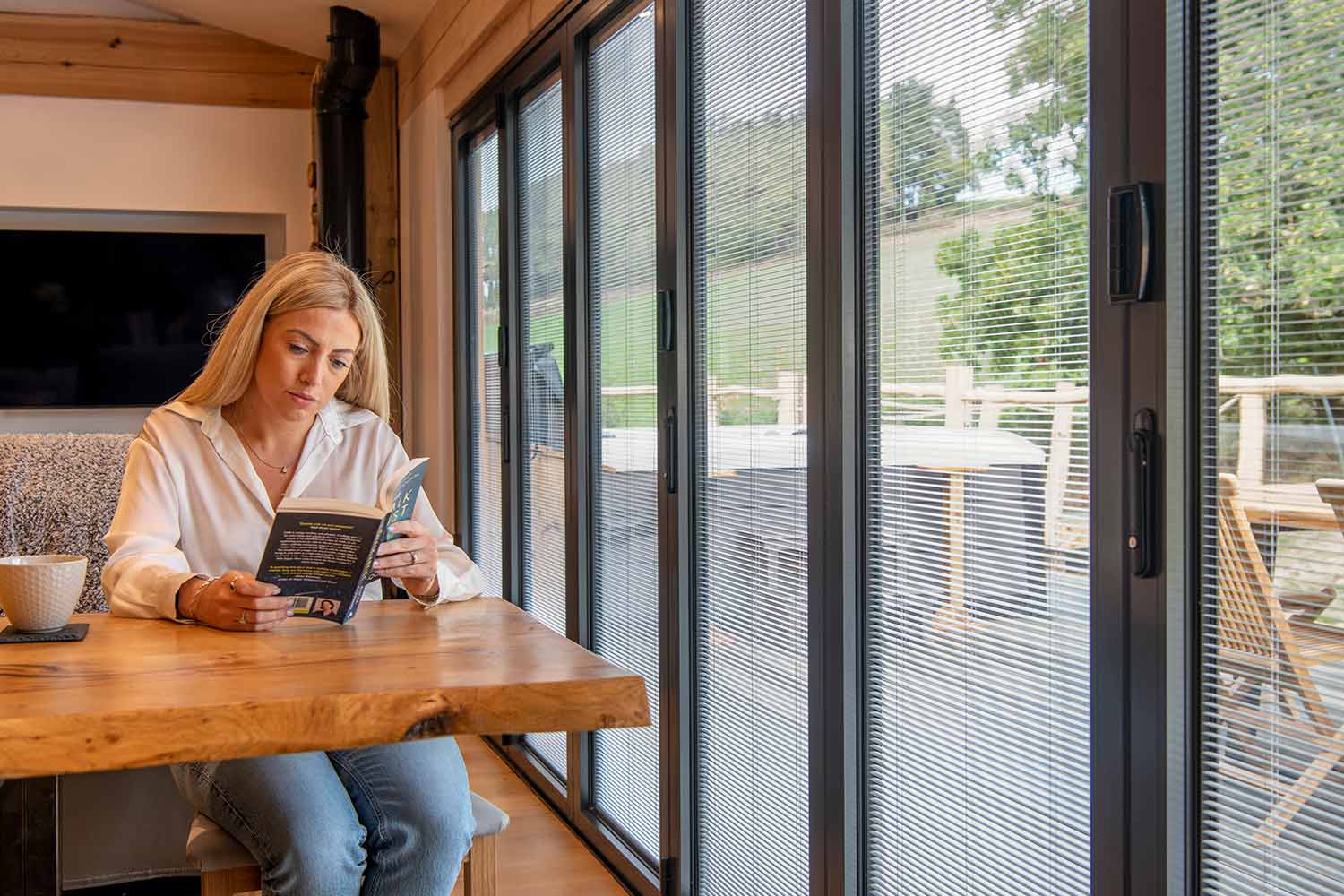 integral blinds in lodge bifold doors beside a reading table, fitted in Hatfield