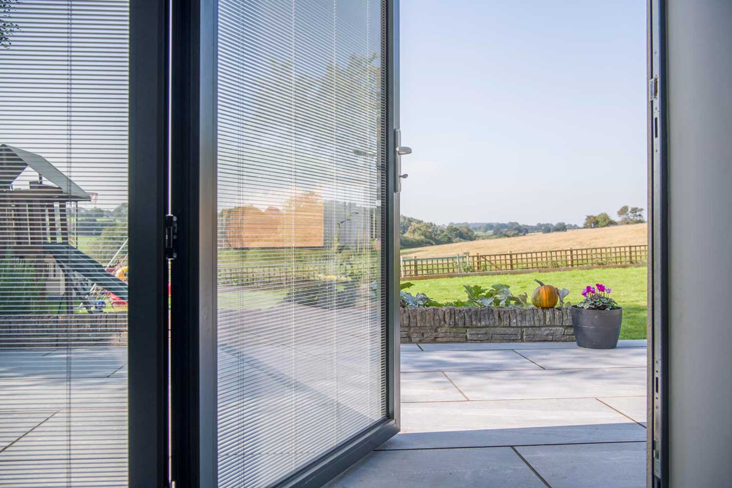 Blinds in Glass in Hatfield: integral blinds in open bifold doors with a countryside view